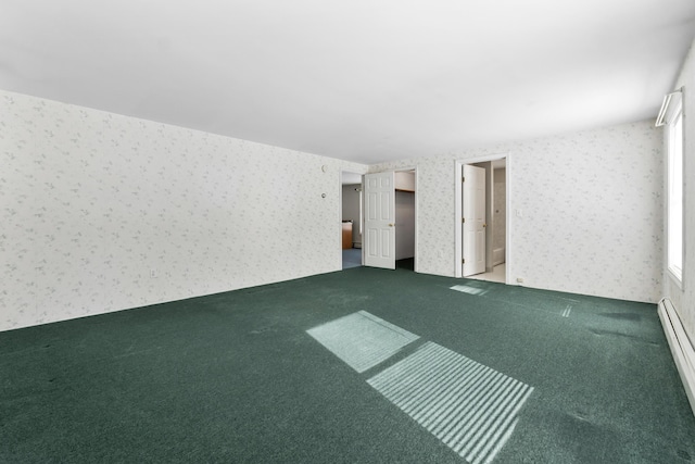 empty room featuring wallpapered walls, carpet, and baseboard heating