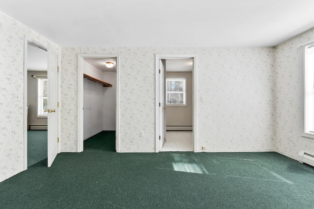 unfurnished bedroom featuring wallpapered walls, a baseboard radiator, multiple windows, and carpet