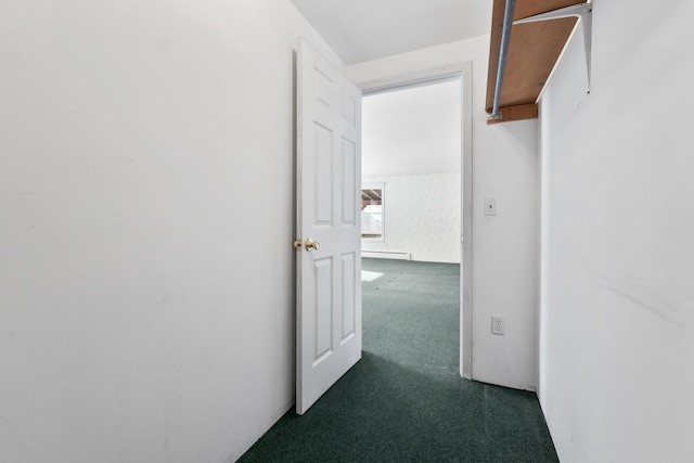 corridor with a baseboard heating unit and dark colored carpet