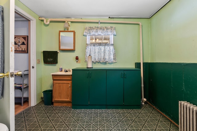 interior space with radiator heating unit, a sink, and tile patterned floors