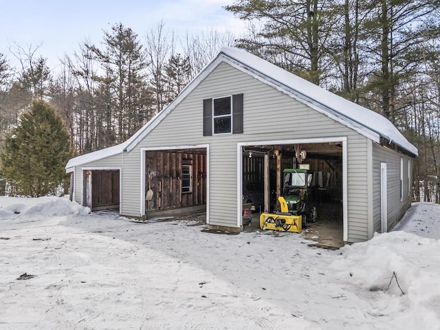 snow covered garage with a detached garage