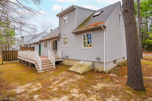 back of property featuring a wooden deck and a shingled roof