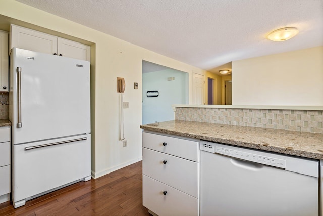 kitchen featuring decorative backsplash, baseboards, white cabinets, dark wood-style floors, and white appliances