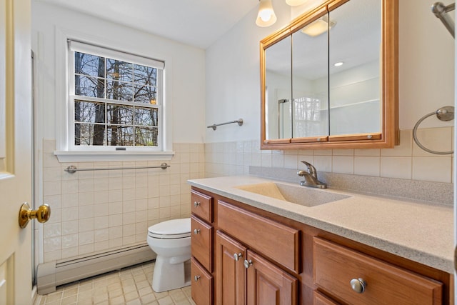 bathroom with vanity, toilet, tile patterned floors, tile walls, and a baseboard radiator
