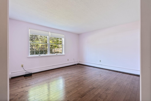 unfurnished room featuring a textured ceiling, baseboard heating, and hardwood / wood-style floors