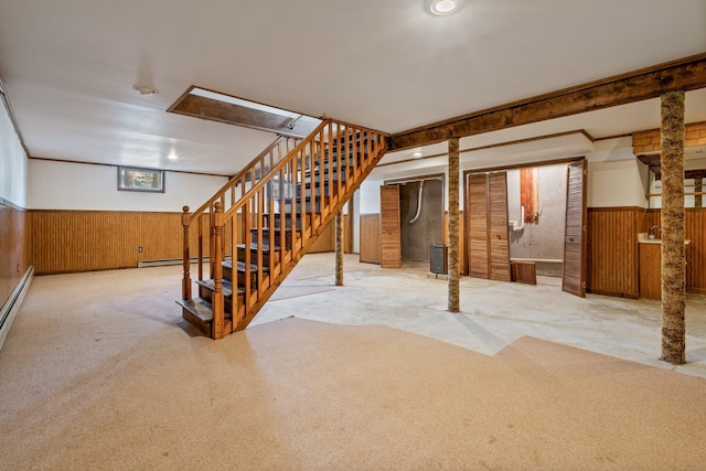 basement with stairway, a wainscoted wall, wood walls, and carpet floors