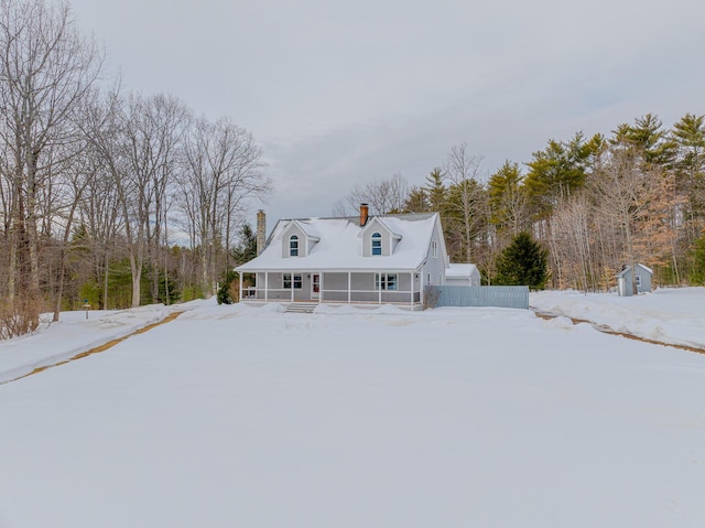 farmhouse-style home featuring an outbuilding, fence, a chimney, and a storage unit