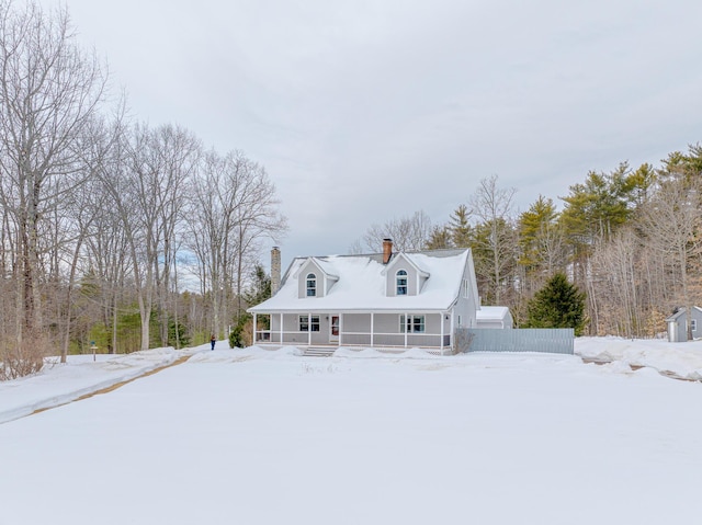 exterior space with covered porch, a chimney, and fence