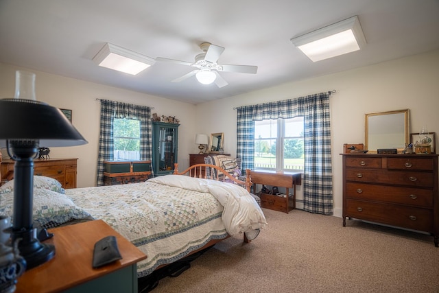 bedroom featuring ceiling fan, multiple windows, and carpet flooring