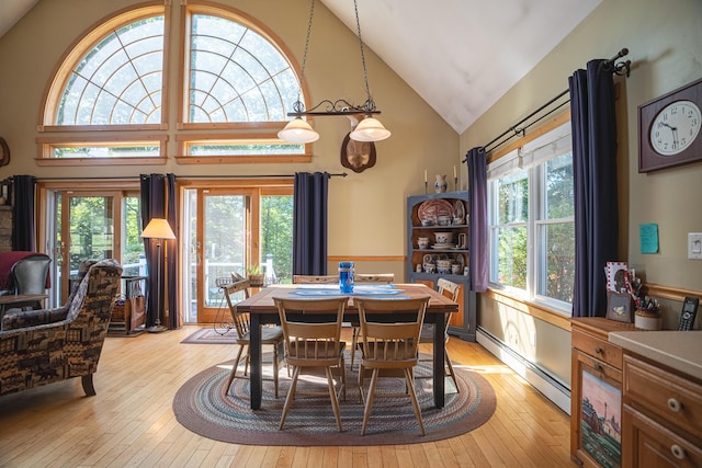 dining area featuring a baseboard heating unit, a wealth of natural light, and light wood-style floors