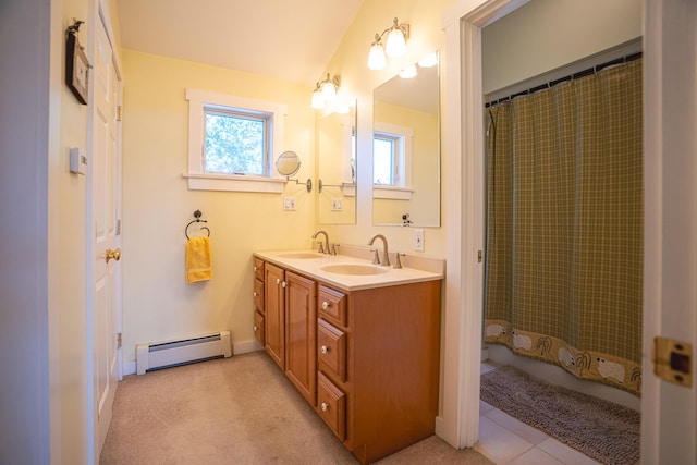 full bathroom featuring a wealth of natural light, a sink, baseboard heating, and double vanity