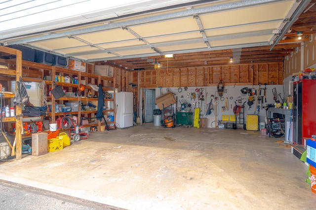 garage with a workshop area and freestanding refrigerator