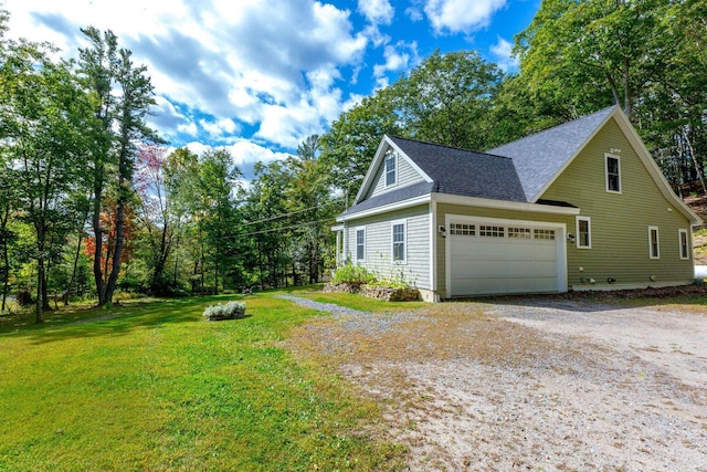 view of side of property with a yard, an attached garage, driveway, and a shingled roof