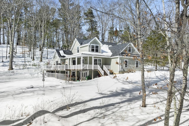 snow covered back of property featuring fence