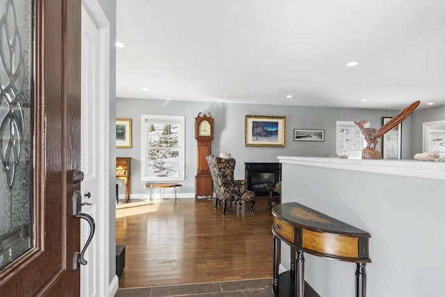 entryway with dark wood-type flooring, a glass covered fireplace, and recessed lighting