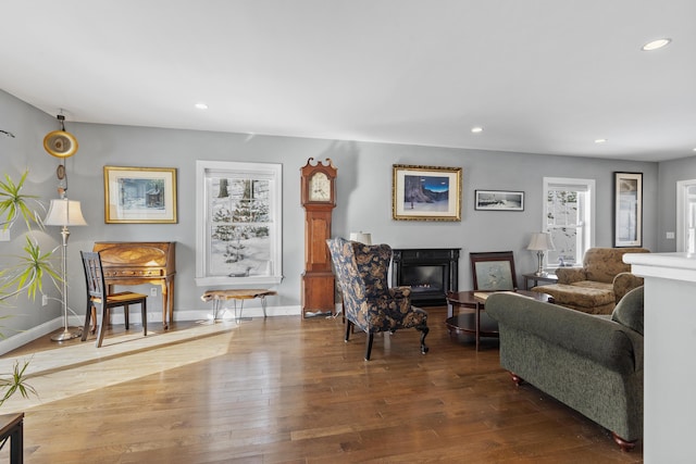 living room with a glass covered fireplace, baseboards, hardwood / wood-style floors, and recessed lighting