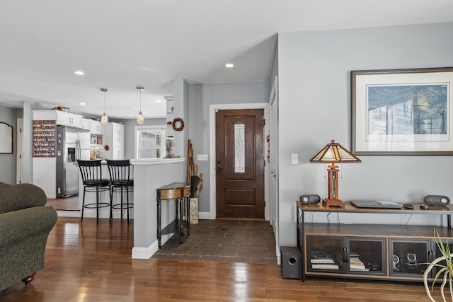 entryway featuring a fireplace, baseboards, dark wood finished floors, and recessed lighting