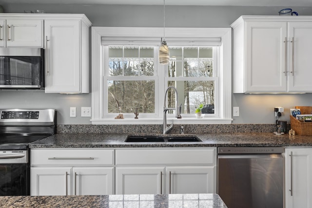 kitchen featuring stainless steel appliances, a healthy amount of sunlight, white cabinetry, and a sink