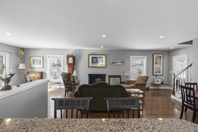 living area featuring a fireplace, baseboards, wood finished floors, and recessed lighting