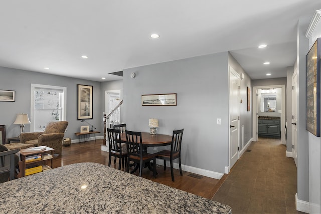 dining space featuring baseboards, wood finished floors, and recessed lighting