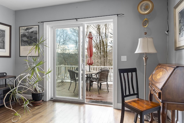 doorway to outside with baseboards and wood finished floors