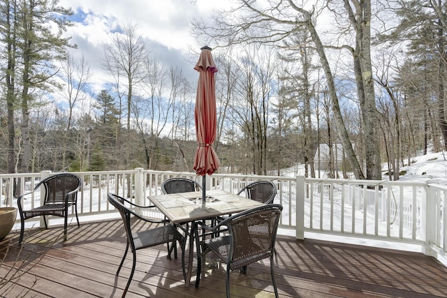 snow covered deck featuring outdoor dining space