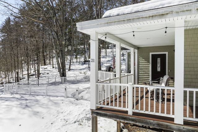 snow covered deck featuring fence