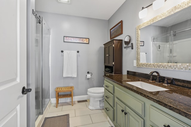 bathroom with toilet, tile patterned flooring, a shower stall, and vanity