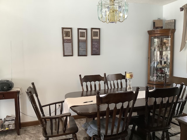 dining space with a chandelier and baseboards