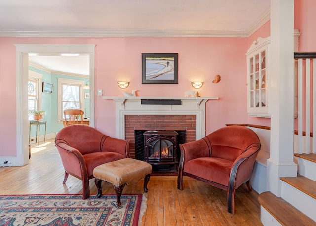 sitting room with a fireplace, baseboards, stairway, hardwood / wood-style floors, and crown molding