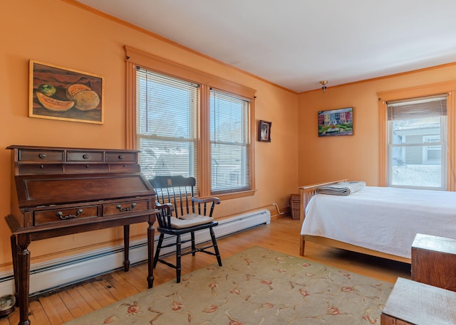 bedroom with a baseboard radiator, wood finished floors, and crown molding