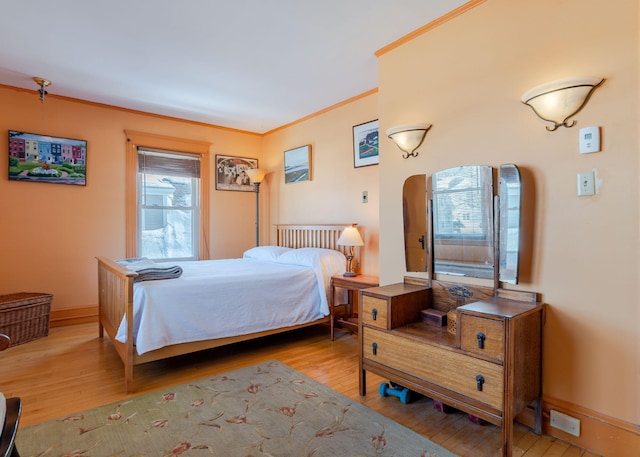 bedroom with crown molding, baseboards, and wood finished floors