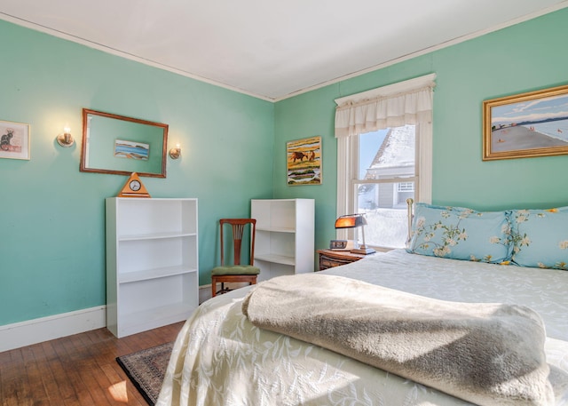 bedroom featuring ornamental molding, wood-type flooring, and baseboards