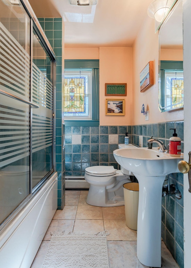 full bathroom featuring a wainscoted wall, shower / bath combination with glass door, tile walls, toilet, and tile patterned flooring