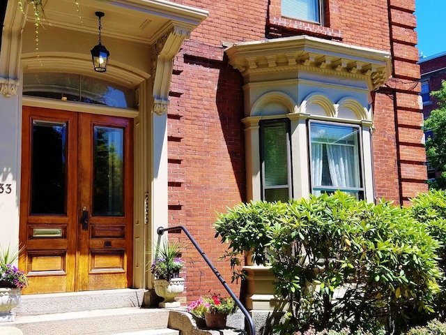 entrance to property featuring french doors and brick siding