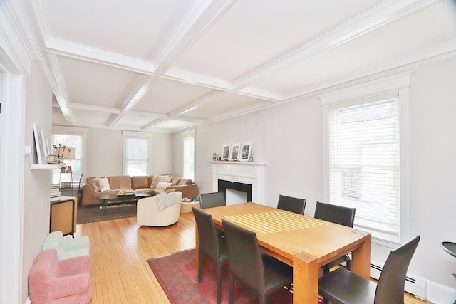 dining room with a fireplace, light wood-style floors, a baseboard heating unit, coffered ceiling, and beamed ceiling