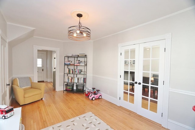 sitting room featuring baseboards, ornamental molding, wood finished floors, french doors, and a notable chandelier