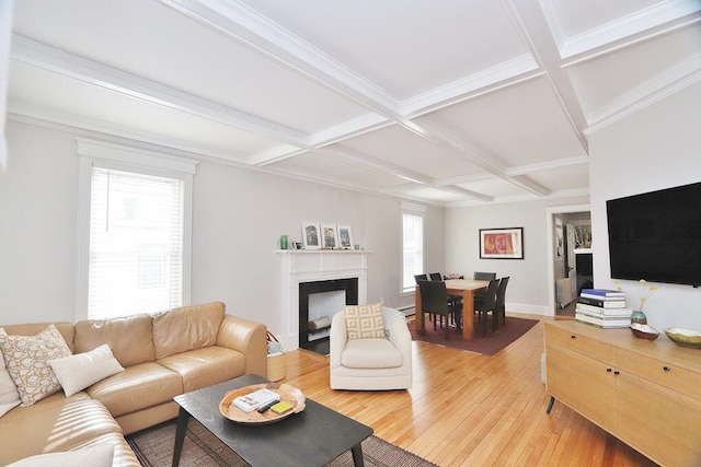 living area featuring baseboards, coffered ceiling, light wood-style flooring, beamed ceiling, and a fireplace