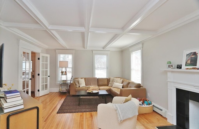 living area featuring a baseboard heating unit, coffered ceiling, wood finished floors, and french doors