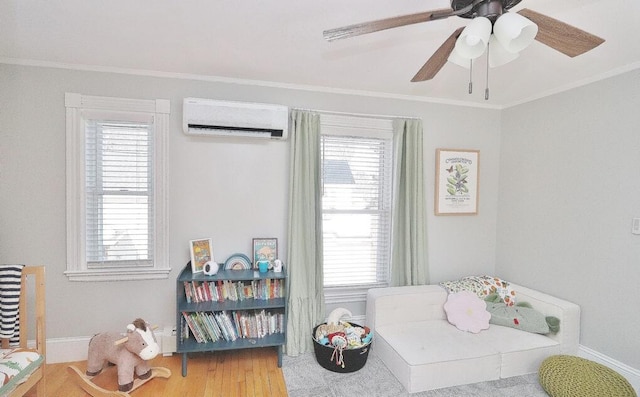 bedroom featuring ceiling fan, ornamental molding, baseboards, and a wall mounted air conditioner