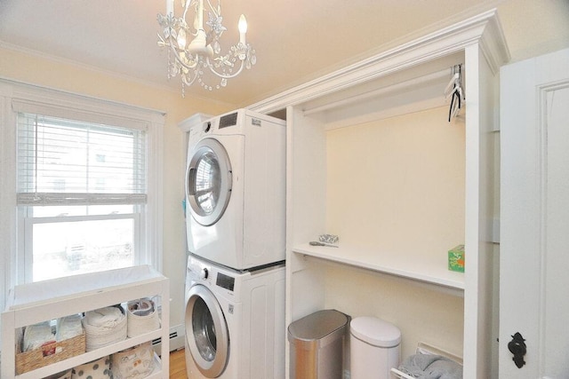 washroom with stacked washer and dryer, laundry area, crown molding, and an inviting chandelier