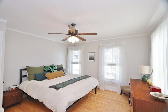 bedroom with ornamental molding, light wood-style flooring, and a ceiling fan