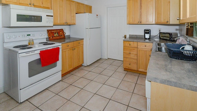 kitchen with light tile patterned floors, dark countertops, light brown cabinetry, a sink, and white appliances