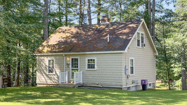 rear view of house featuring a lawn and a chimney