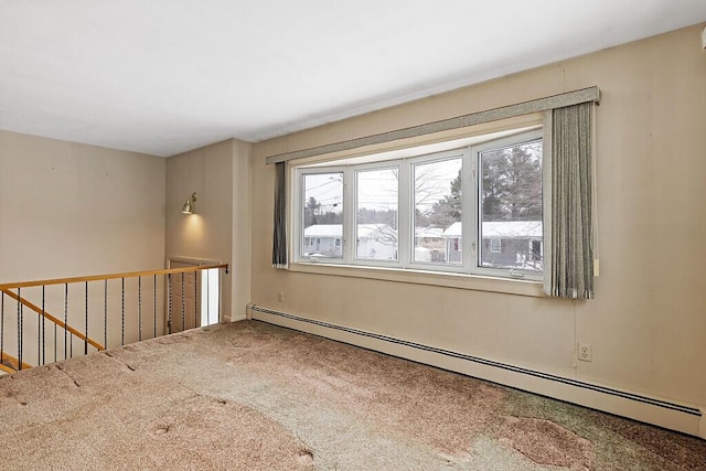 spare room featuring carpet, a baseboard radiator, and a wealth of natural light