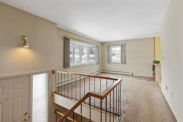 carpeted entryway with baseboards, stairway, and baseboard heating