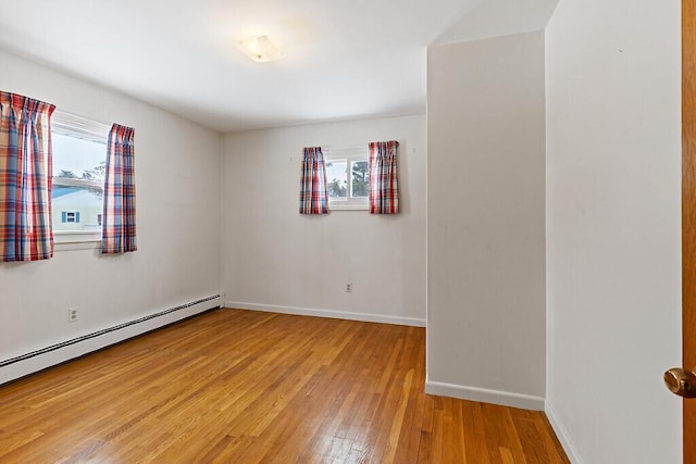 empty room with light wood-style floors, plenty of natural light, baseboards, and baseboard heating