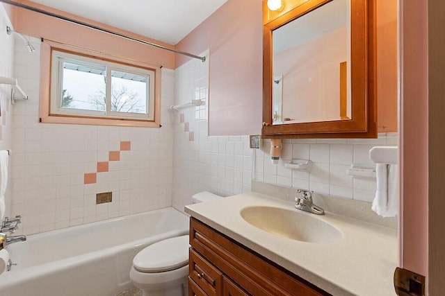 full bath with tile walls, shower / tub combination, vanity, and toilet