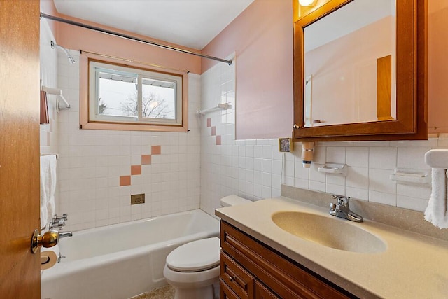 bathroom with tile walls, shower / tub combination, vanity, and toilet