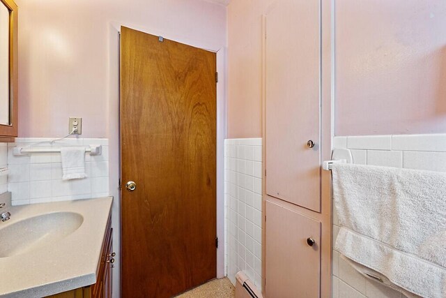 bathroom with a wainscoted wall, vanity, and tile walls